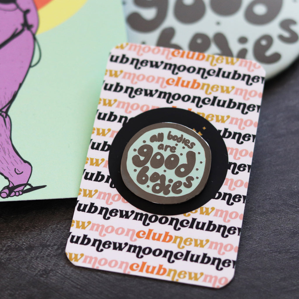 all bodies are good bodies mint green enamel pin on desk 