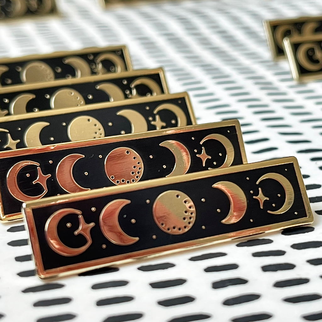 moon phases enamel pin badges on table 